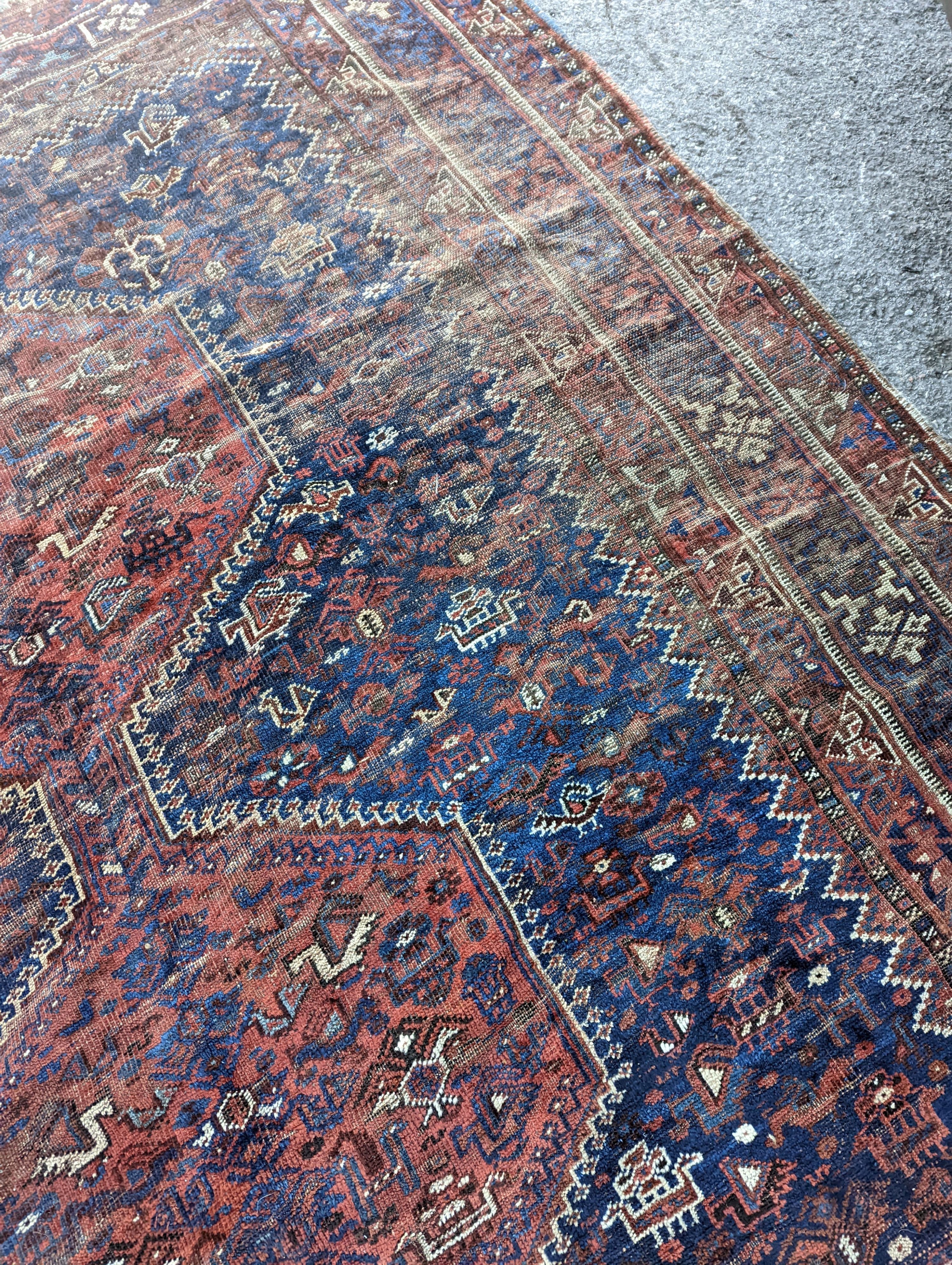 An antique Shirvan red ground carpet (worn), 295 x 207cm